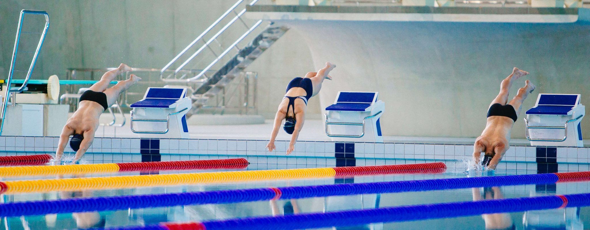 Three people starting a swimming race