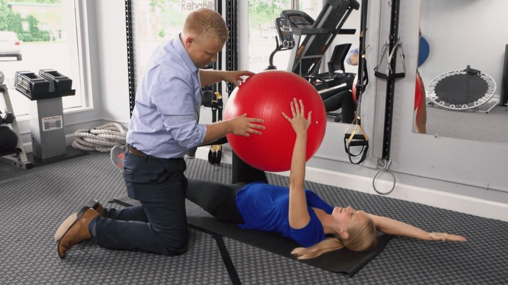 Dr. Douglas Ryan Evenhouse working one on one with a patient on core strength physical rehabilitation